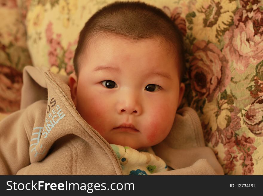 Lovely Chinese baby sitting in a chair. Lovely Chinese baby sitting in a chair