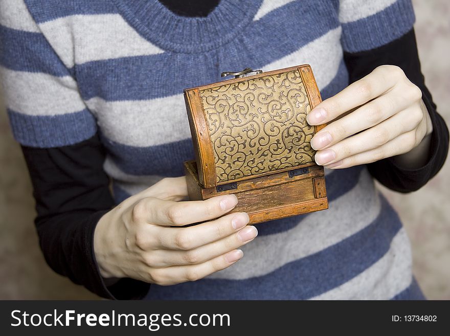 Hands of a young girl holding a decorative wooden box. Secret. Hands of a young girl holding a decorative wooden box. Secret