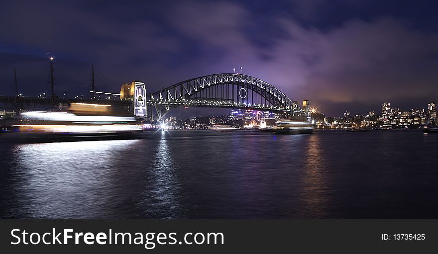 Sydney harbor bridge at dark with ship passing