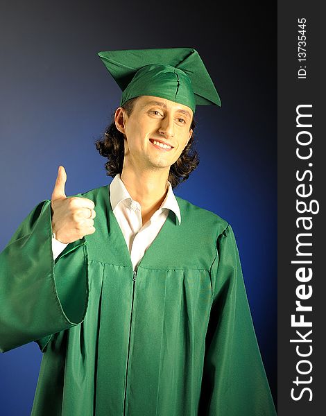 Portrait of a succesful man on his graduation day in green clothes and a hat