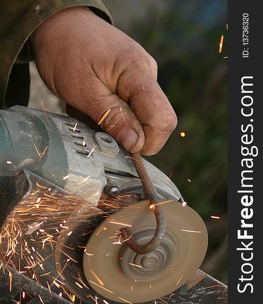 Hand of the worker with the electric tool for are sharp metal. Hand of the worker with the electric tool for are sharp metal