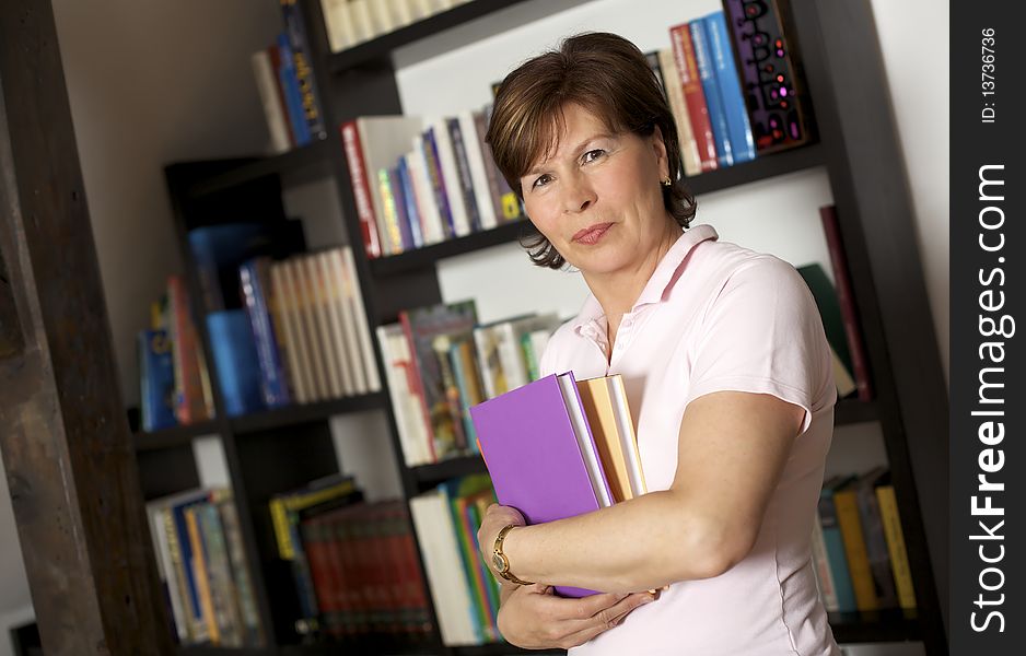 Friendly senior woman carrying books