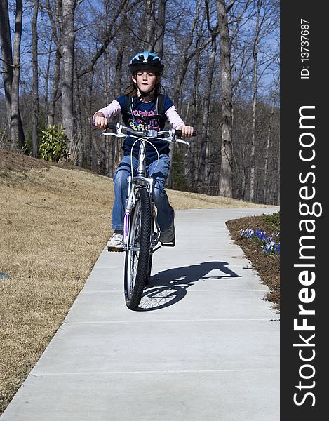 A young girl riding on a path with a cute expression of enjoyment. A young girl riding on a path with a cute expression of enjoyment.