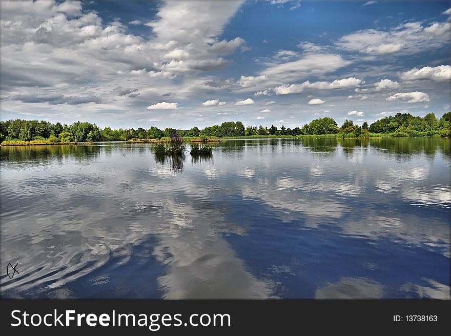 Summer pond under blue sky background