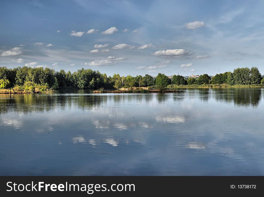 Summer pond under blue sky background