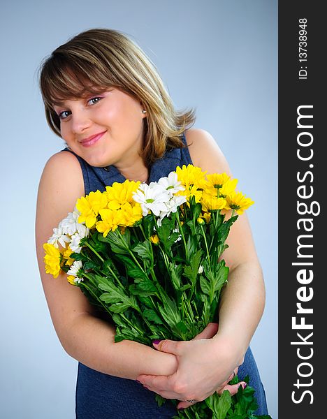 Young cute pregnant girl with bouquet of flowers