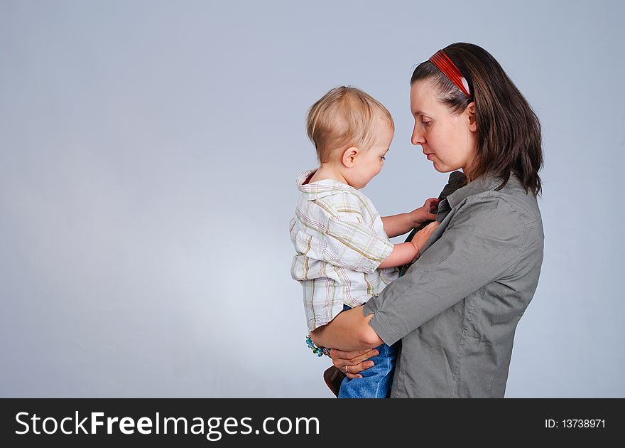 Happy mother holding hands and kissing his little son. Happy mother holding hands and kissing his little son