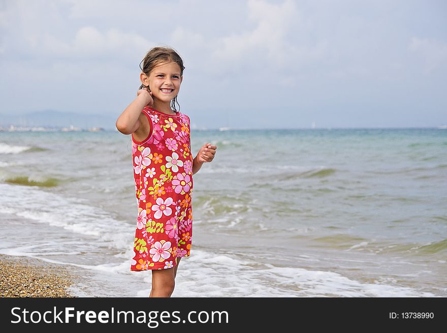 Sweet beautiful girl in a bright dress looks on the sea. Sweet beautiful girl in a bright dress looks on the sea