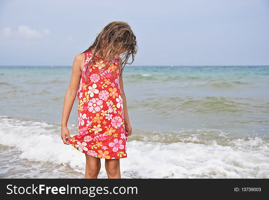 Sweet beautiful girl in a bright dress looks on the sea. Sweet beautiful girl in a bright dress looks on the sea