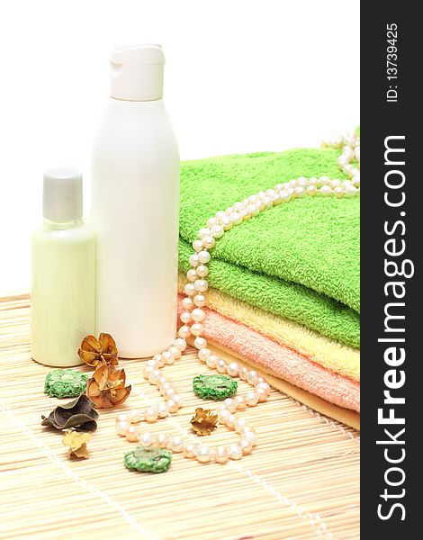 Shampoo, cream, towels, a pearl beads on a white background. Shampoo, cream, towels, a pearl beads on a white background