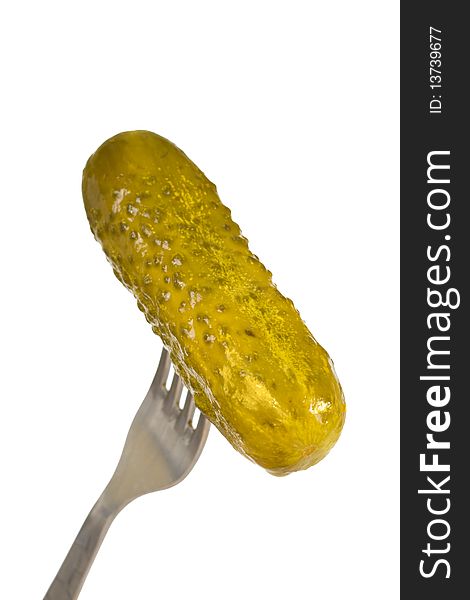 Pickled cucumber on a fork isolated on white