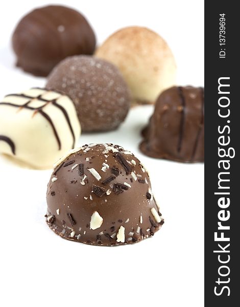 Chocolate truffles, selection viewed from side on white