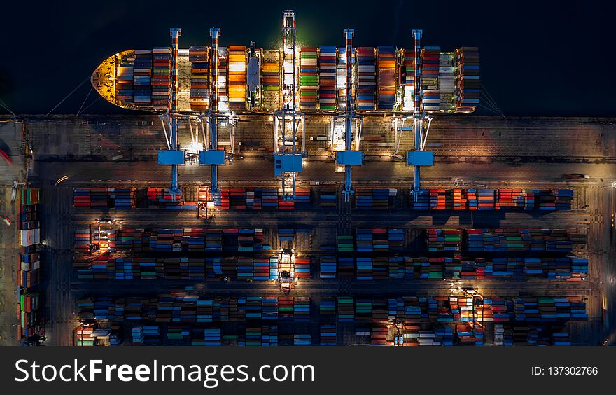 Container ship in import export business logistic at night, Aerial top view of container ship.