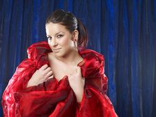 Young Woman In Red Silk On Blue Background Royalty Free Stock Image