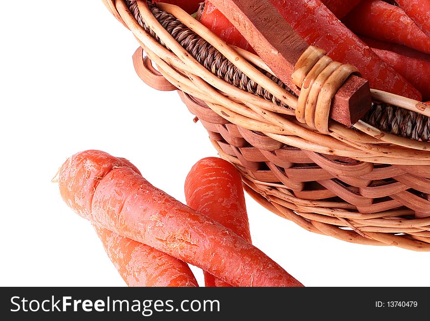 Carrot crop in a wattled basket on a white background.