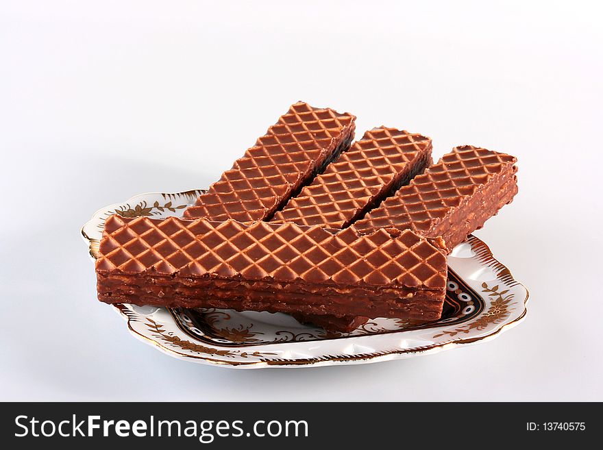 Wafers in chocolate glaze on a ceramic plate.