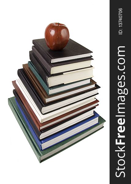 Pile of text books & apple isolated against white