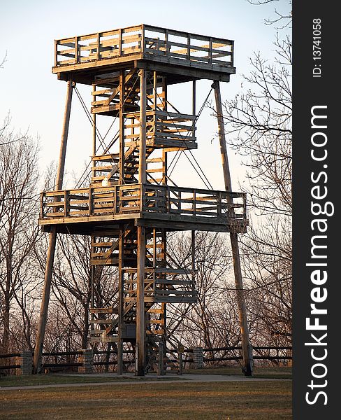 A huge fire watch tower or ranger station overlooks hundreds of acres of forest.