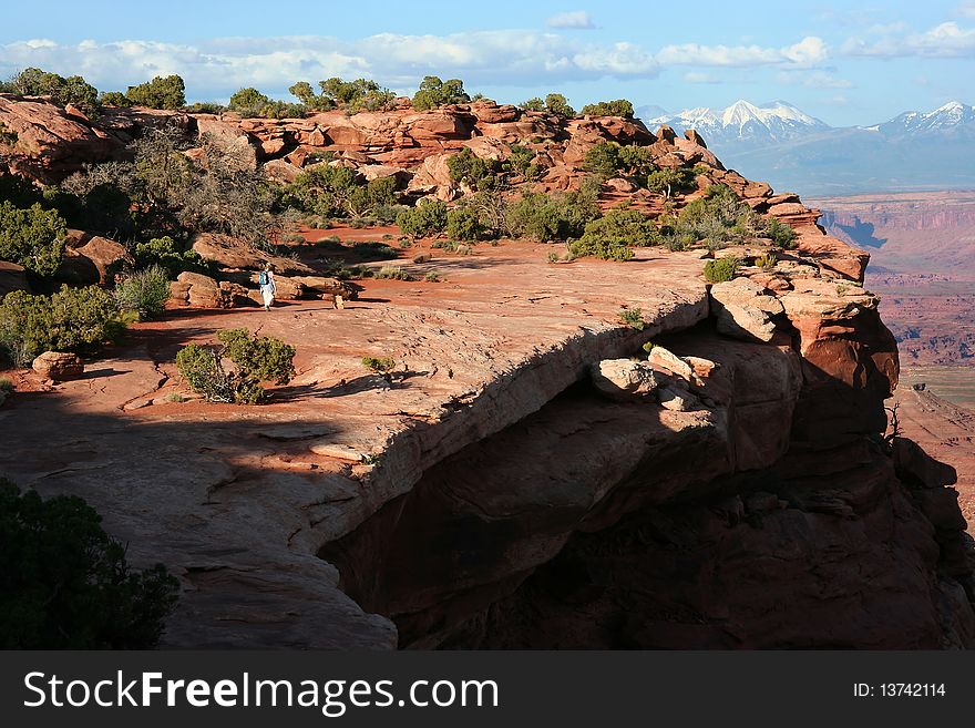 A woman walking on a cliff on Island In The Sky, Canyonlands National Park in Utah, USA. A woman walking on a cliff on Island In The Sky, Canyonlands National Park in Utah, USA