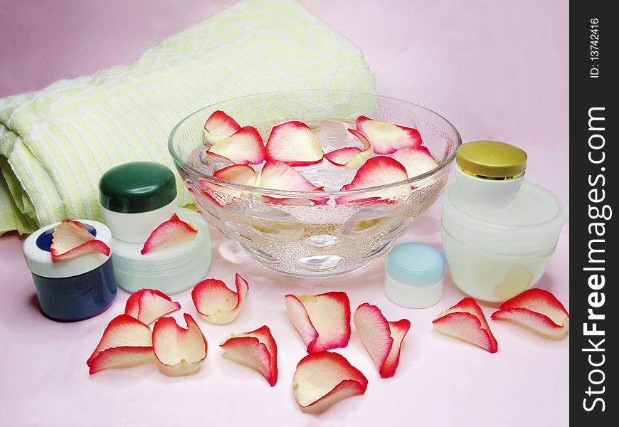 Spa bowl with pink water with rose petals and cremes. Spa bowl with pink water with rose petals and cremes
