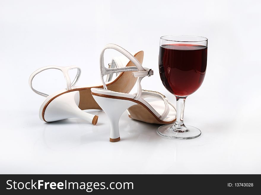 Women's shoes next to a glass and an emotional image. Women's shoes next to a glass and an emotional image