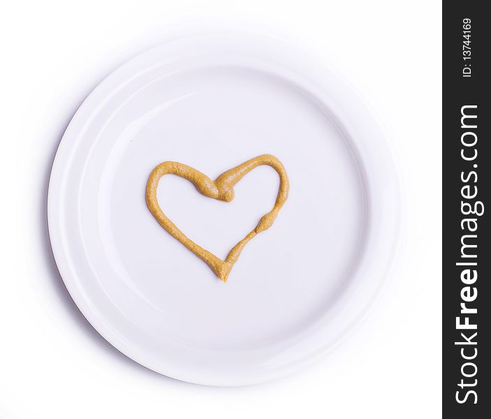Heart mustard on white plate (isolated on white backgound)