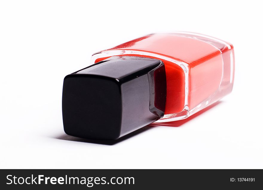 Vertical image of red nail polish on a white backg