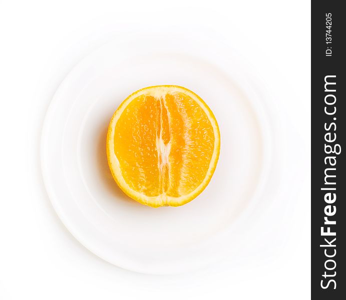 Slice of orange on white plate isolated on white