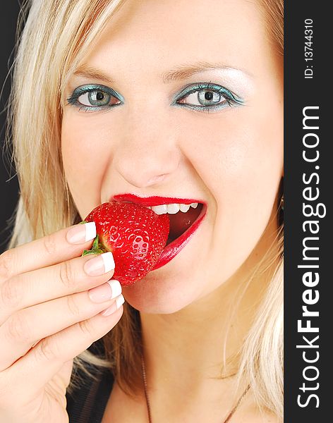 Beautiful blond girl with red lips eating a fresh strawberry. Portrait studio shoot. Beautiful blond girl with red lips eating a fresh strawberry. Portrait studio shoot.