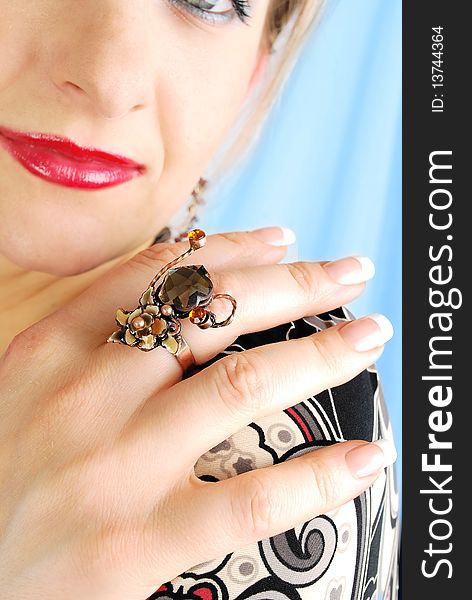 Beautiful woman's  fingers with modern ring and nice French manicure n the face with red lips background. . Beautiful woman's  fingers with modern ring and nice French manicure n the face with red lips background. .