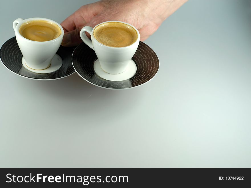 Hand serving two espresso cups