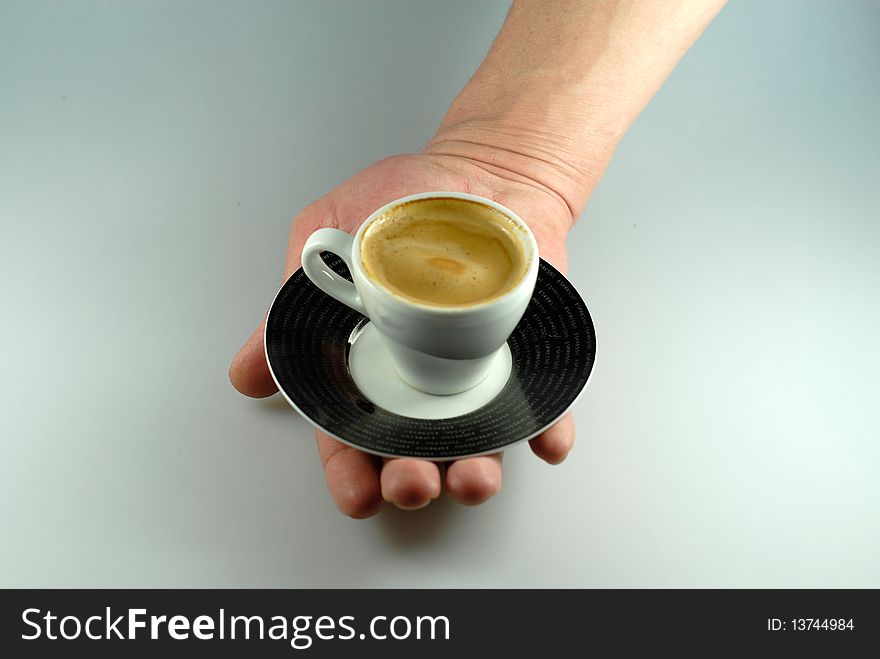 Hand serving an espresso cup