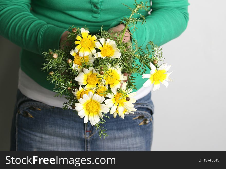 A woman holds a bouquet of daisies. A woman holds a bouquet of daisies