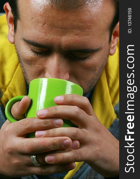 An image of a charismatic man drinking tea. An image of a charismatic man drinking tea