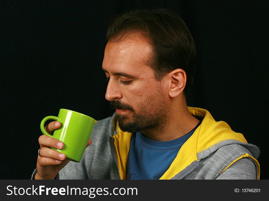 While the image of a charismatic man drinking tea. While the image of a charismatic man drinking tea