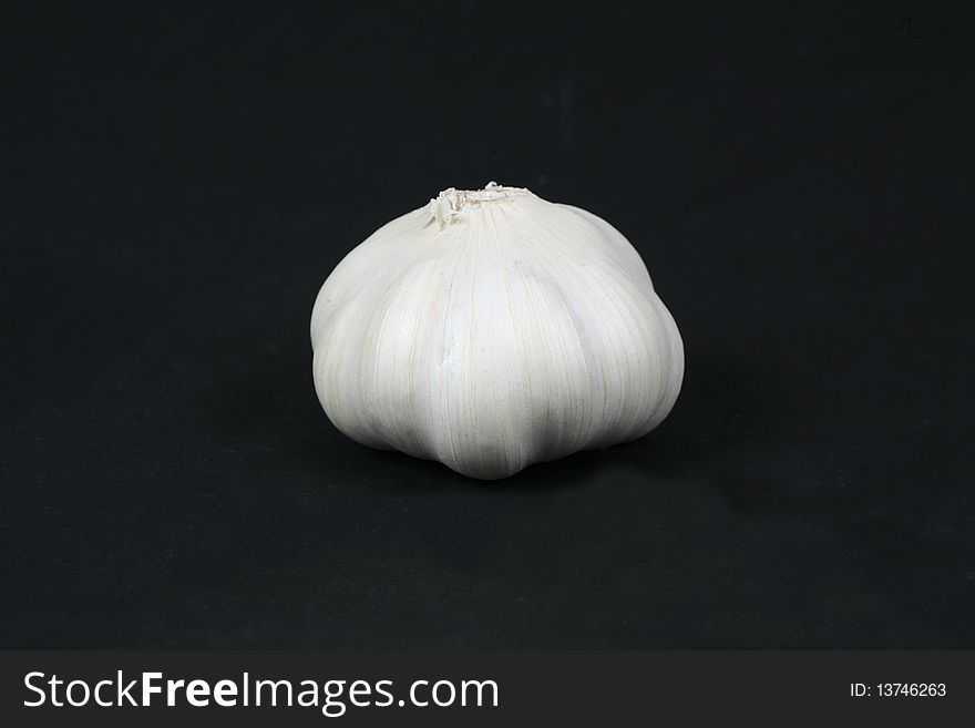 Health store garlic in white on black background. Health store garlic in white on black background