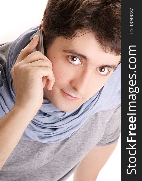 Young attractive smiling man in blue scarf speaking on phone on white bakground. Young attractive smiling man in blue scarf speaking on phone on white bakground