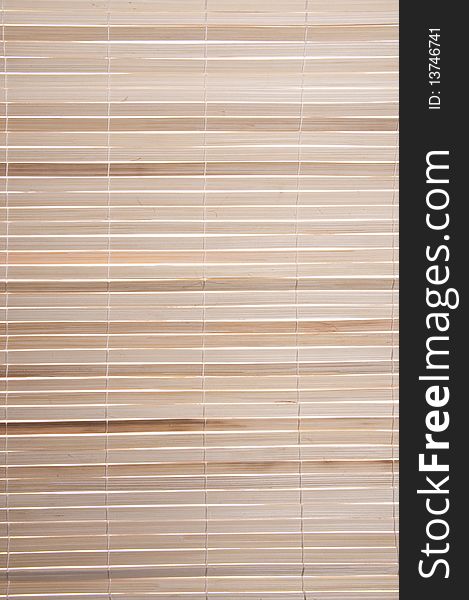 Backlit bamboo shade background image with light colored wood.