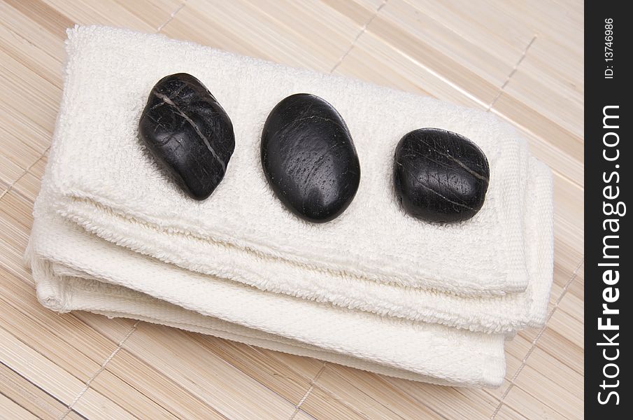 Towel with Massage Stones on a bamboo background.