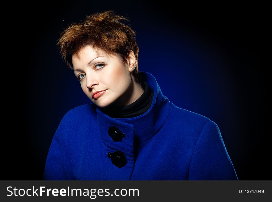 Young lady with short hair dressed in a blue topcoat. Young lady with short hair dressed in a blue topcoat