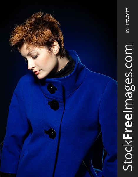 Young lady with short hair dressed in a blue topcoat. Young lady with short hair dressed in a blue topcoat