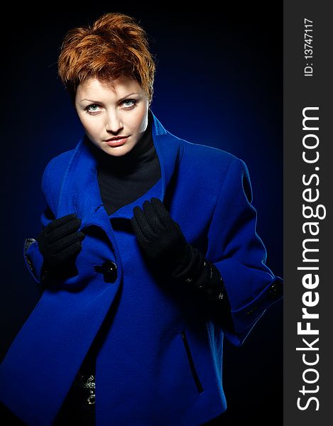 Young lady with short hair dressed in a blue topcoat. Young lady with short hair dressed in a blue topcoat