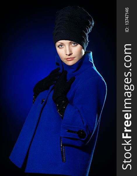 Young lady dressed in a blue topcoat and black hat. Young lady dressed in a blue topcoat and black hat