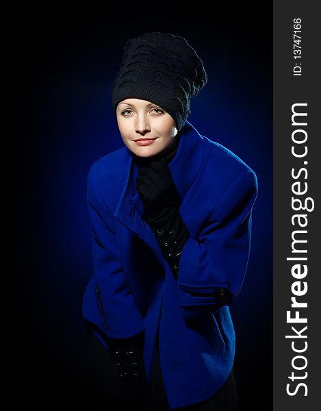 Young lady dressed in a blue topcoat and black hat. Young lady dressed in a blue topcoat and black hat