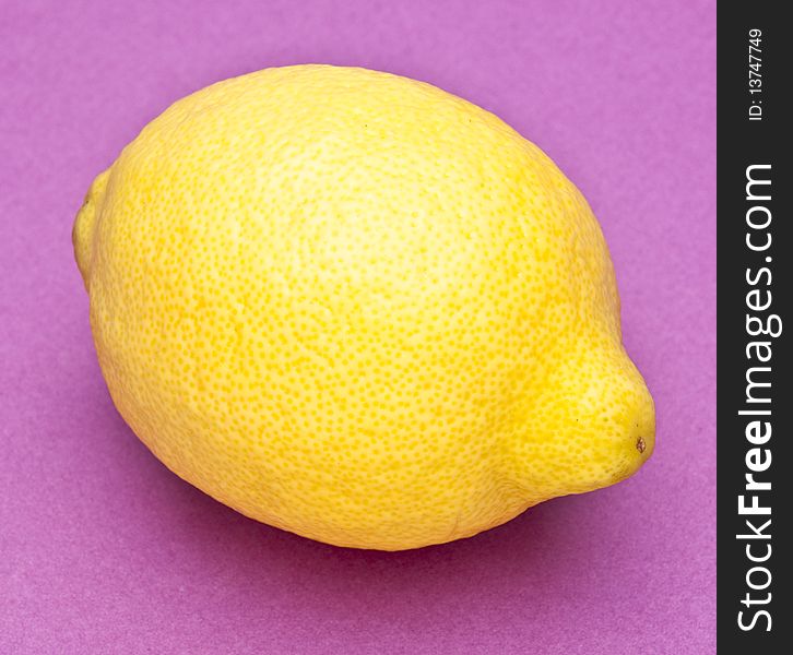 Lemon on a vibrant purple colored background. Lemon on a vibrant purple colored background