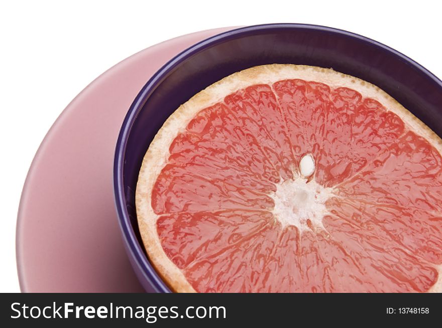Vibrant sliced grapefruit in a bowl isolated on white with a clipping path.