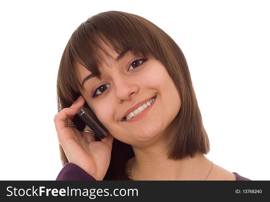 Young pretty girl standing with a phone on a white background