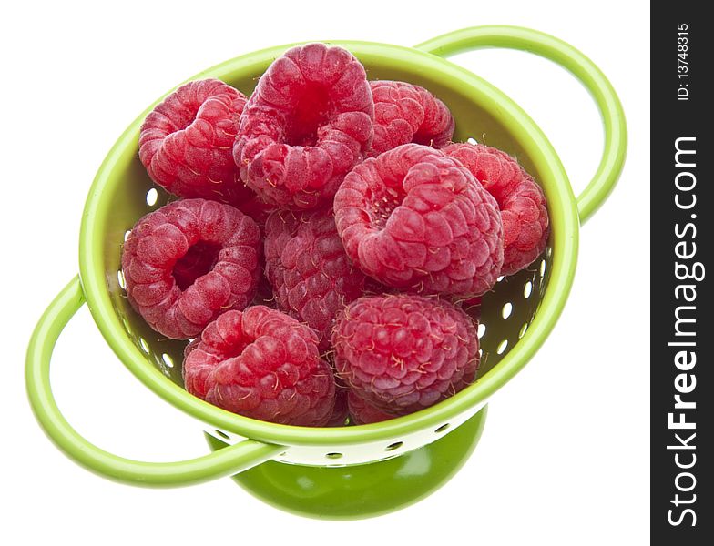 Fresh raspberries in a bright green colander isolated on white with a clipping path. Fresh raspberries in a bright green colander isolated on white with a clipping path.