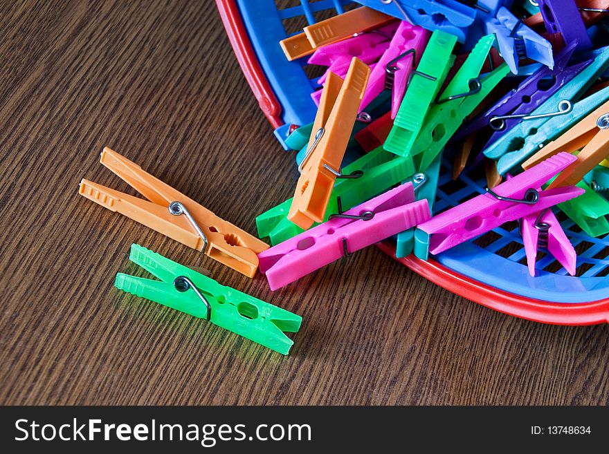 Colored clothespins from basket placed on table