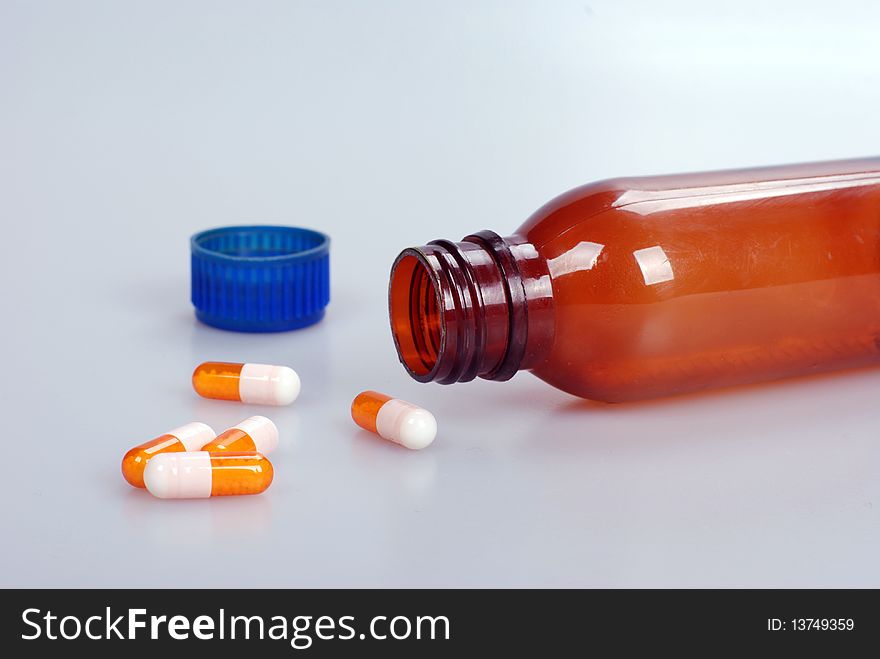 Macro shot of medicine capsules with bottle